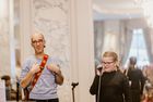 Eine Schülerin singt am Mirkofon. Andrew Bond steht im Hintergrund und klatscht in die Hände