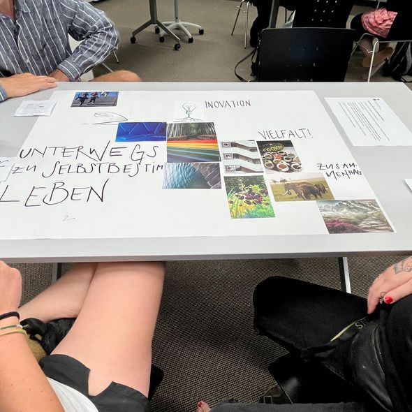 Mitarbeitende der Blindenschule sitzen am Tisch und schreiben in Stichworten, wo sie die Blindenschule in Zukunft sehen. 