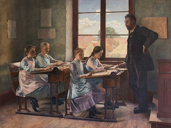 Ein Lehrer steht vor einer Mädchenklasse. Die Schülerinnen sitzen zu zweit am Pult.